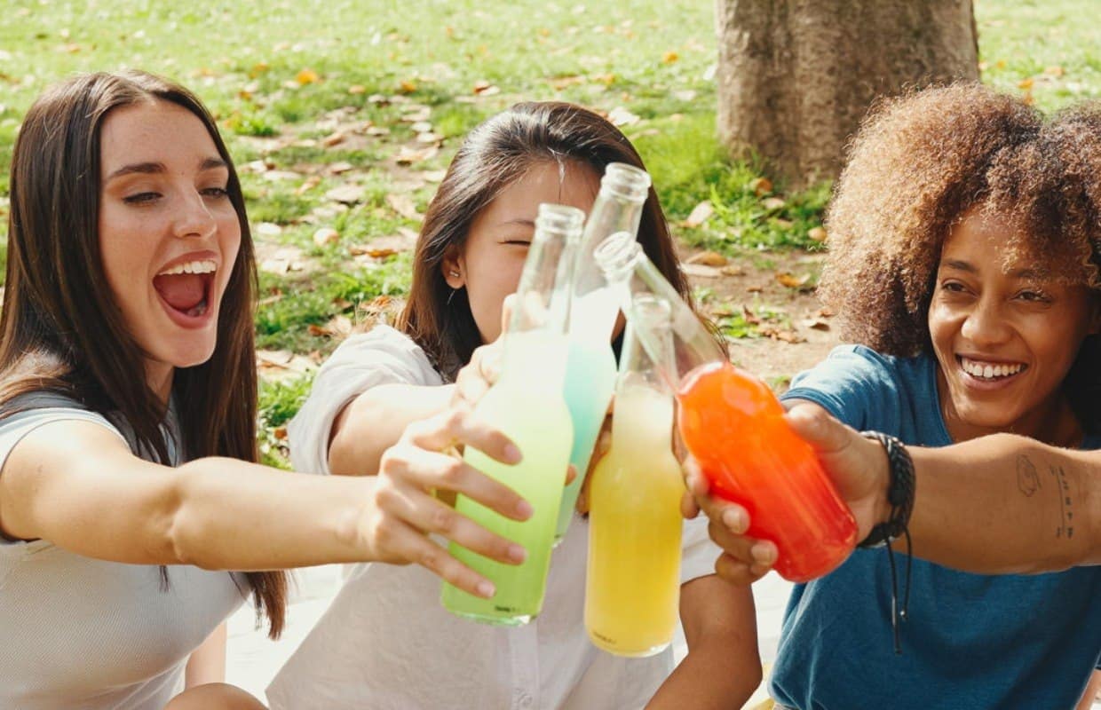 friends drinking soda in a park